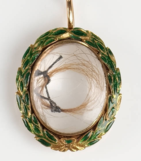 Anhänger mit Medaillon, darin das Haar von Wolfgang Amadeus Mozart (1756–1791) und Ludwig van Beethoven (1770–1827) zeigt, Wien, Mitte des 19. Jahrhunderts, Emaille, Glas und Gold mit Haar (Internationale Stiftung Mozarteum Salzburg, Mozart Museum)