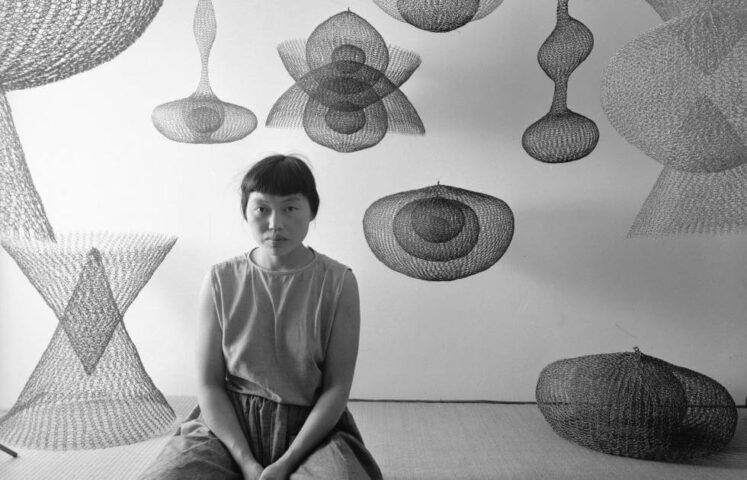 Porträt der japanisch-amerikanischen Künstlerin Ruth Asawa, wie sie inmitten mehrerer ihrer aus Drahtschlingen gefertigten Skulpturen auf dem Boden kniet, November 1954, Detail, Foto: Nat Farbman/The LIFE Picture Collection/Shutterstock, Artwork © 2025 Ruth Asawa Lanier, Inc., Courtesy David Zwirner