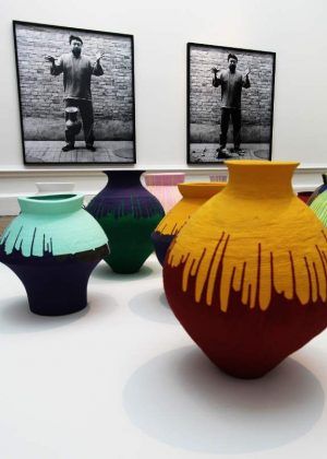 Ai Weiwei, CoaAi Weiwei, Coloured Vases, 2015, antike Vasen mit Industriefarbe bemalt, verschiedene Größen, Privatsammlung und Sammlung von Lisa und Danny Goldberg. Im Hintergrund: Dropping a Han Dynasty Urn, 1995, Triptychon, Schwarz-weiß Fotografien, je 199,9 x 180 cm, Ausstellungsansicht Royal Academy, London 2015, Foto: Alexandra Matzner.loured Vases, 2015, Zwölf Vasen aus der Han Dynastie (206 vor Chr.- 220 nach Chr.) und vier neolithische (5000-3000 vor Chr.) mit Industriefarbe bemalt, verschiedene Größen, Privatsammlung und Sammlung von Lisa und Danny Goldberg. Im Hintergrund: Dropping a Han Dynasty Urn, 1995, Triptychon, Schwarz-weiß Fotografien, je 199,9 x 180 cm, Ausstellungsansicht Royal Academy, London 2015, Foto: Alexandra Matzner.